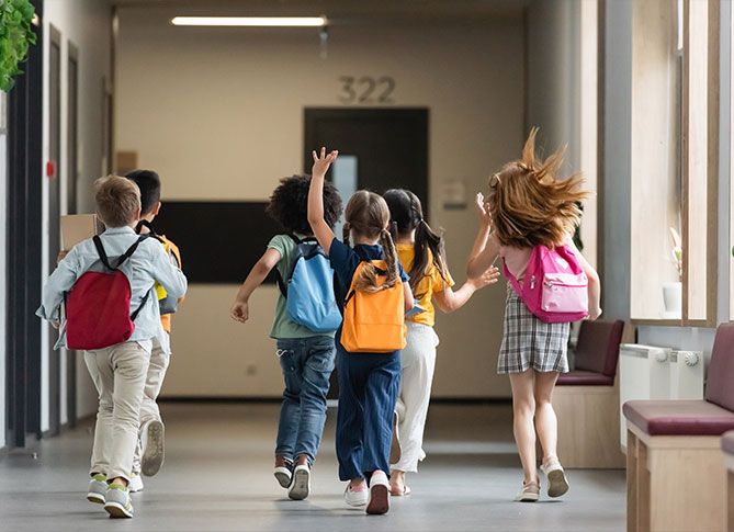 Kids running down a school hallway